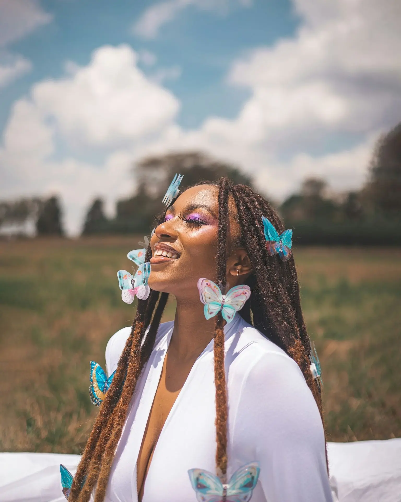 A woman with long braids and blue butterflies on her face